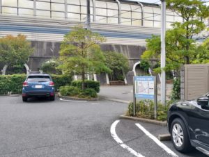 介護施設の建物外観と駐車場。青いのれんが見える玄関エリア
